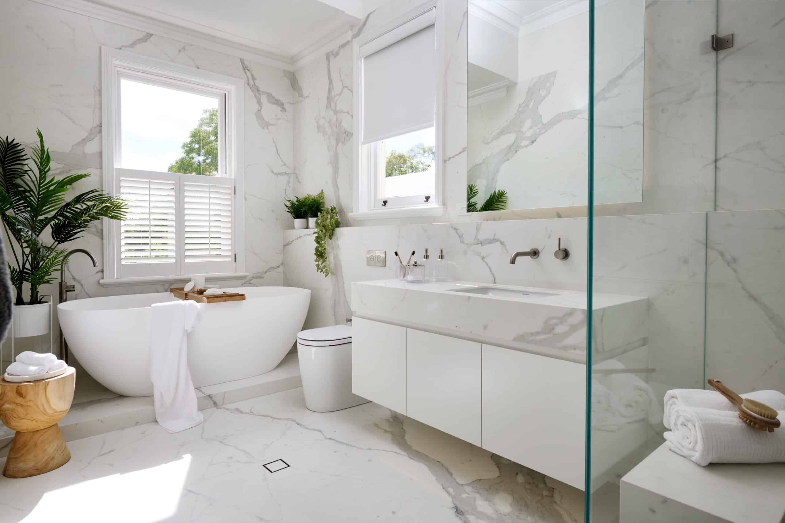 A photo of a bathroom, newly renovated by Lux Interiors. There is a large bathtub, sink and shower.