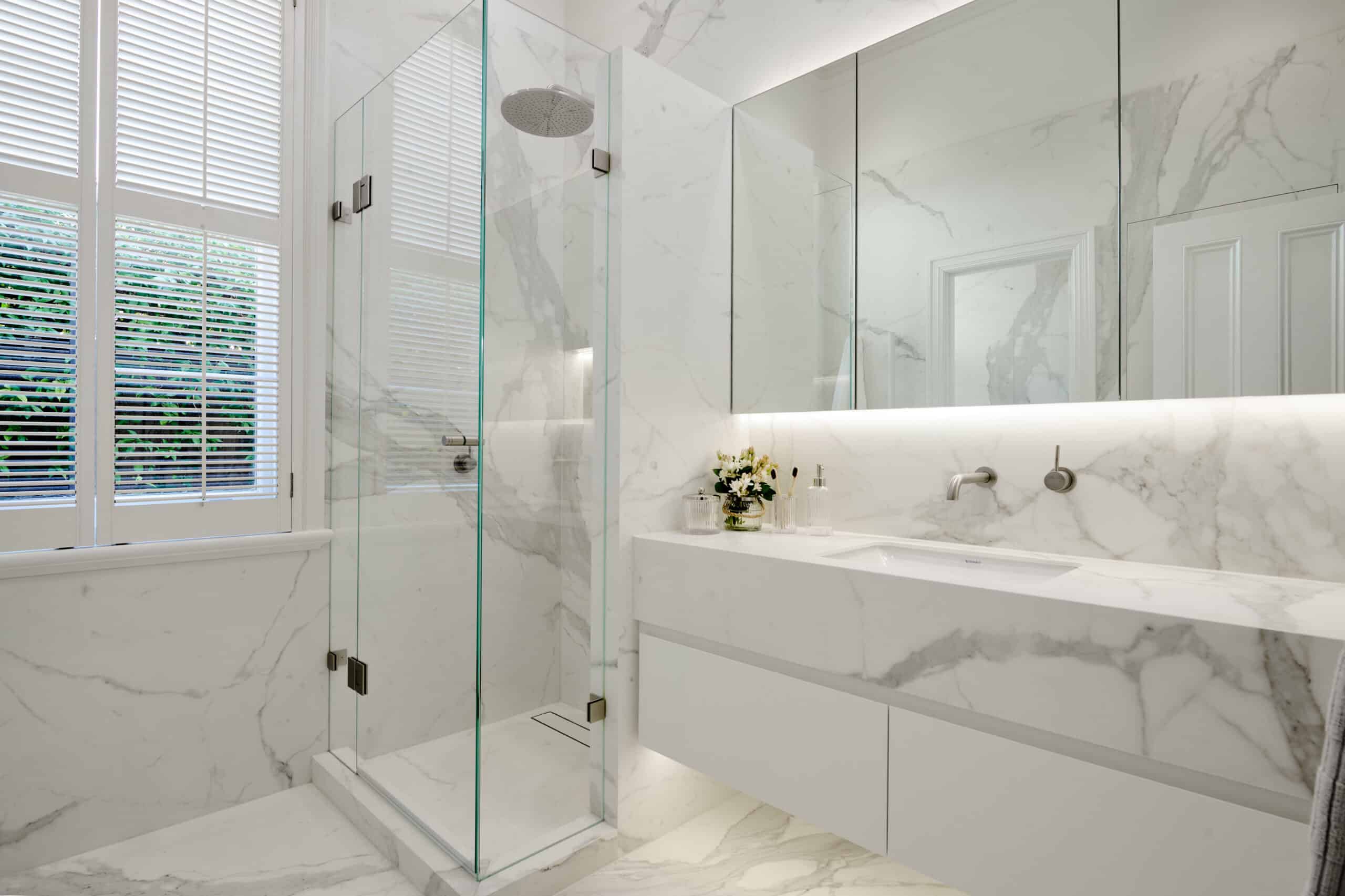 A photo of a newly renovated bathroom, with a shower and sink.