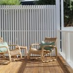 A photo of 2 chairs, sitting facing each other, on the back patio of the house.