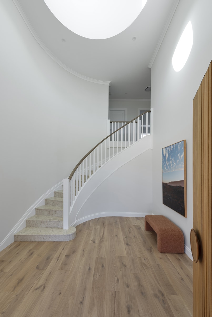 A photo of a white, curved staircase.