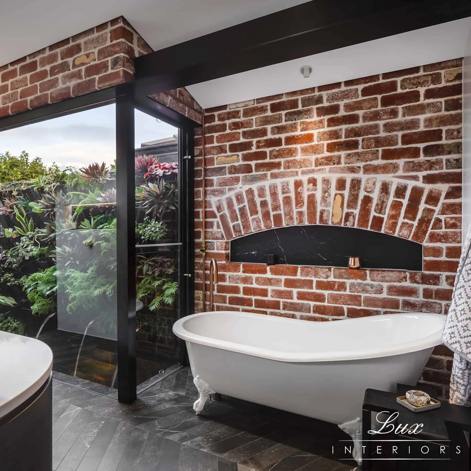 A photo of a bathroom with a bath tub and brick walls.