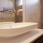 A photo of a sink, with a shower sitting behind.