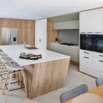 A photo of a kitchen, with wooden walls and white table.