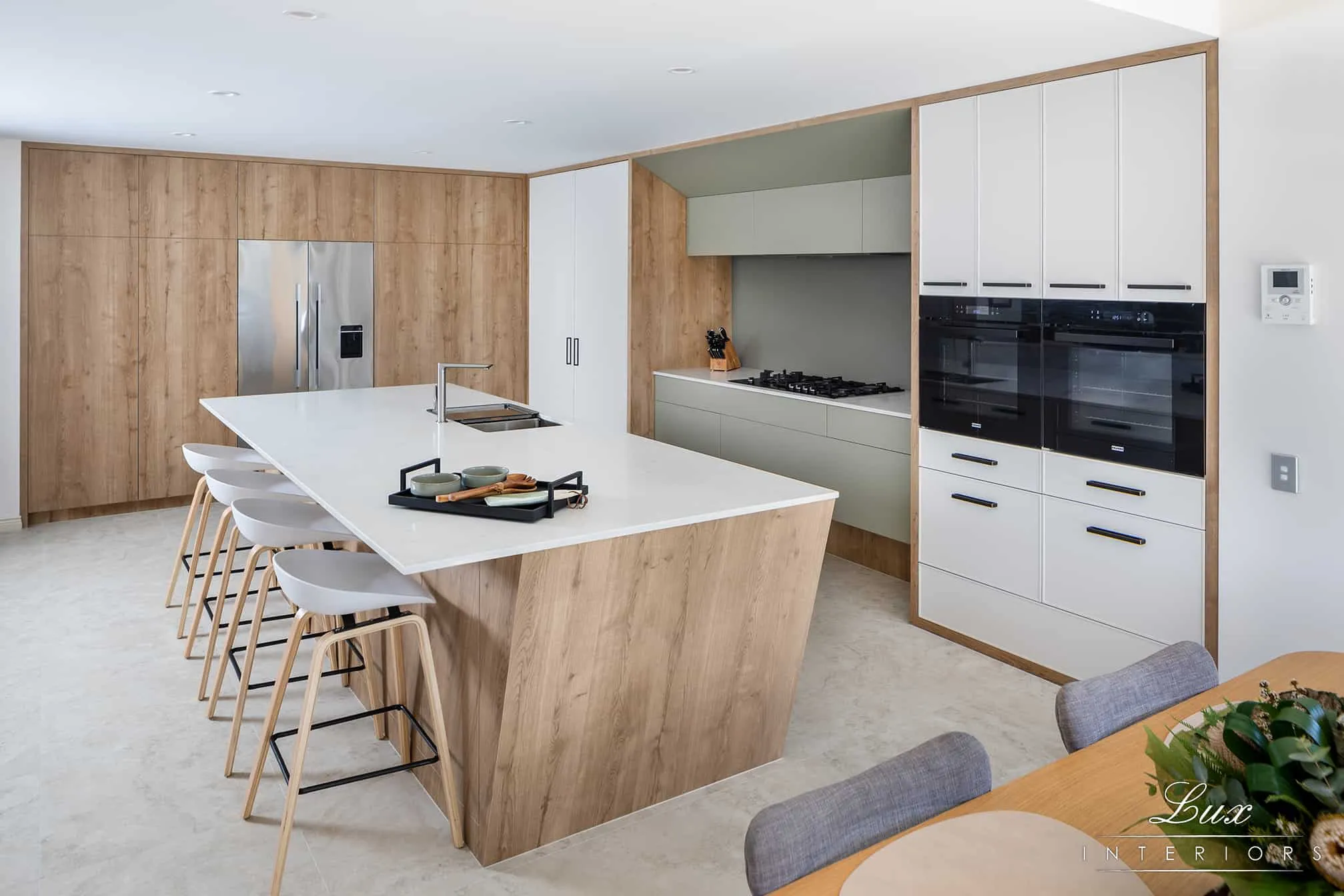 A photo of a kitchen, with wooden walls and white table.