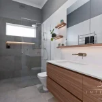 A photo of a bathroom with a shower, toilet and sink.