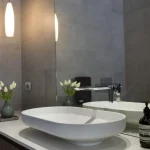 A photo of a bathroom with a sink and large mirror.