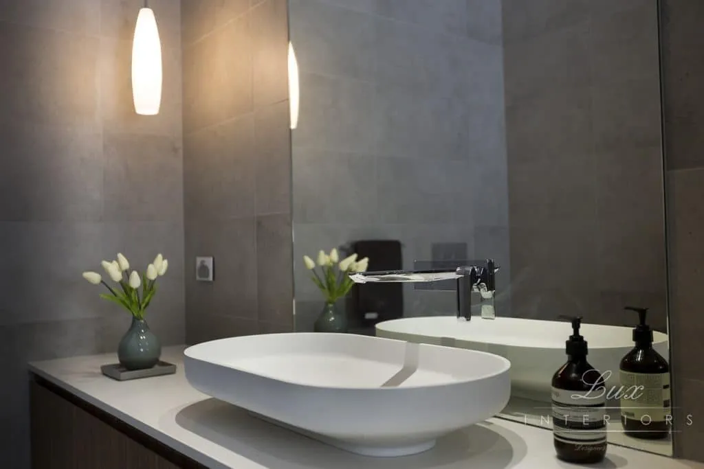 A photo of a bathroom with a sink and large mirror.