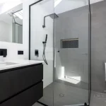 A photo of a bathroom with a sink, toilet and shower.