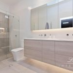 A photo of a bathroom, with a large shower, mirror, sink and toilet.