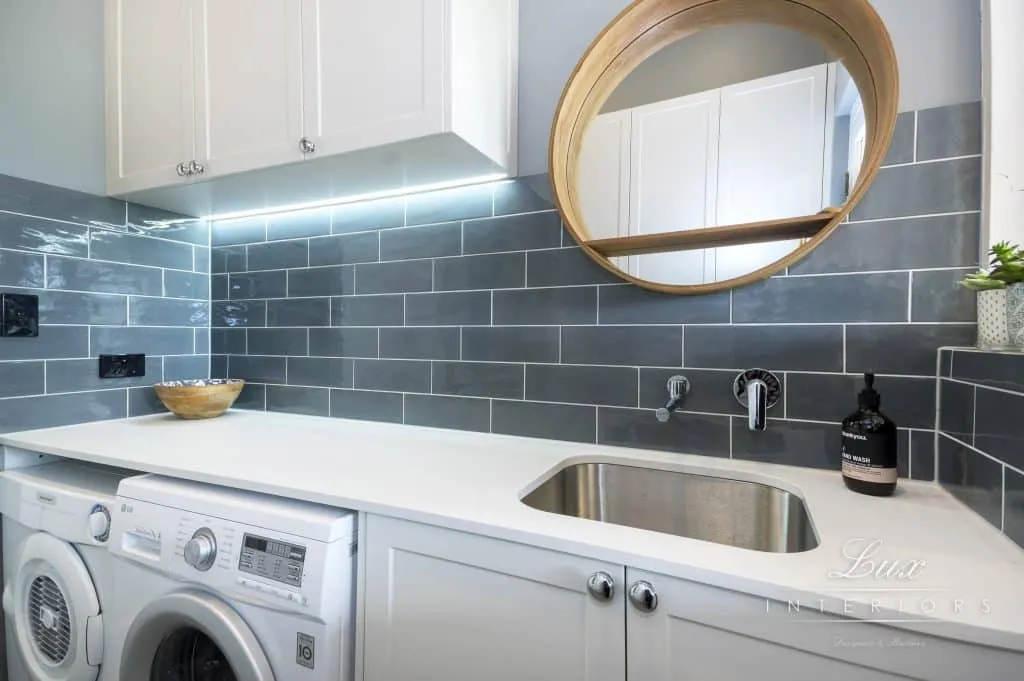 A photo of a laundry area, with a sink, washing machine and dryer.