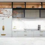 A photo of a kitchen, with a wabi-sabi, japanese feel to it, with white marble tables and black cabinets.