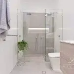 A photo of a bathroom with a shower, toilet and sink.