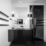 A photo of a bathroom with a black sink and shower.