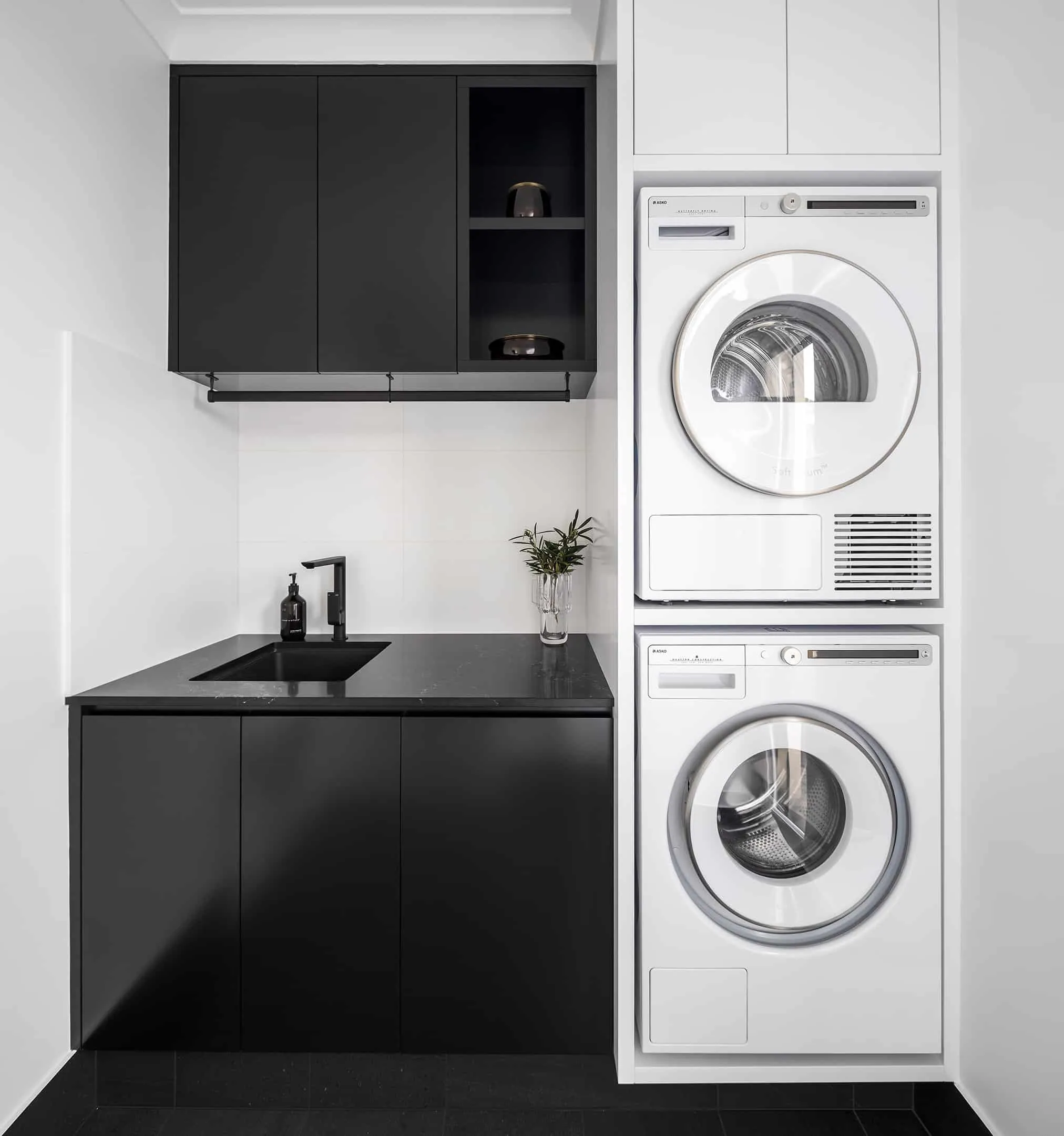 A photo of a laundry, with sink, washing machine and dryer.