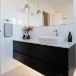 A photo of a bathroom with a sink and large mirror.