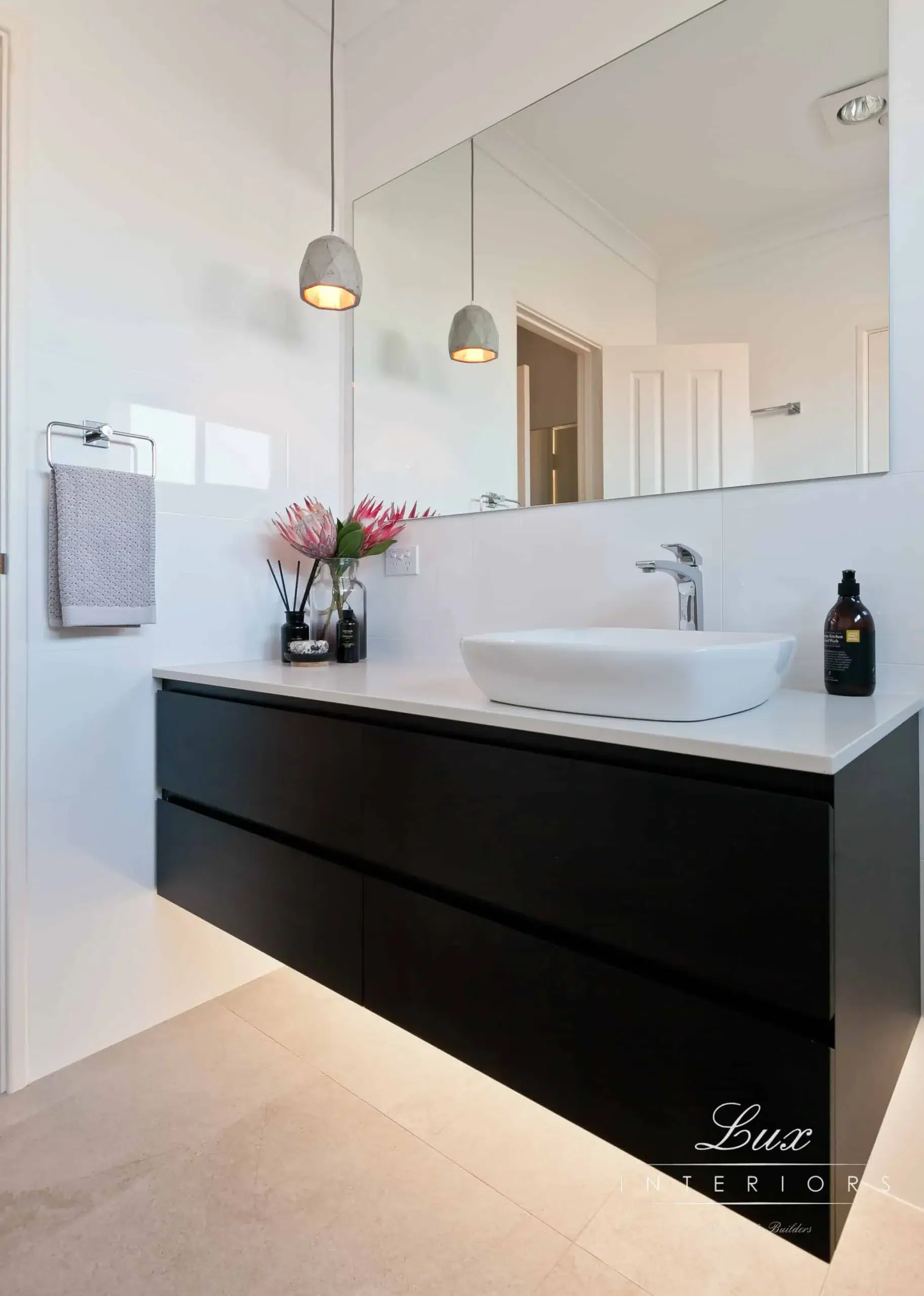 A photo of a bathroom with a sink and large mirror.