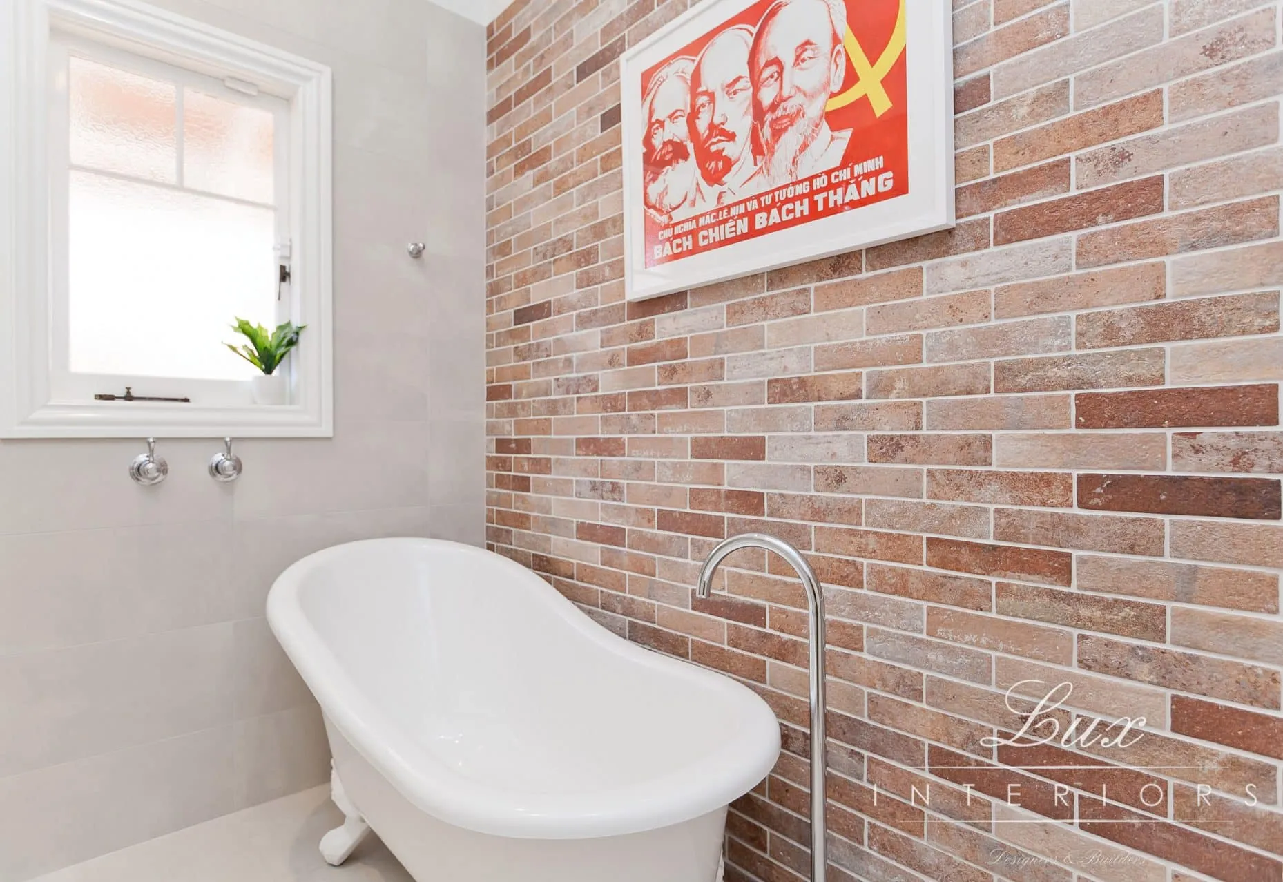 A photo of a bathroom with a bathtub and a full brick wall in the background.