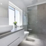 A photo of a bathroom with a sink, toilet and shower.