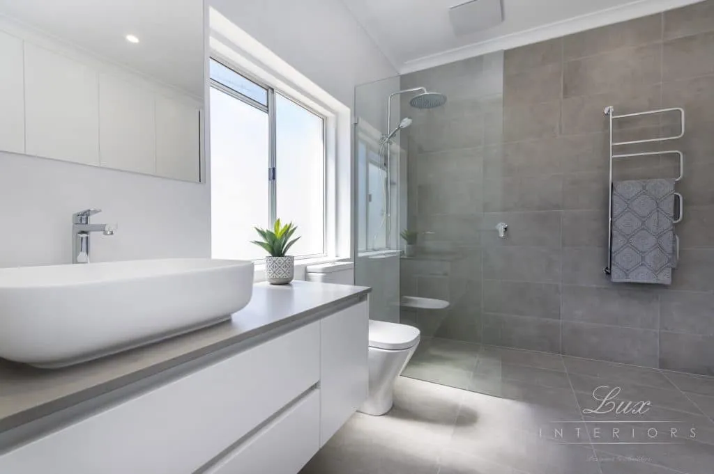 A photo of a bathroom with a sink, toilet and shower.