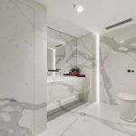 A photo of a bathroom with a huge mirror, sink and toilet.