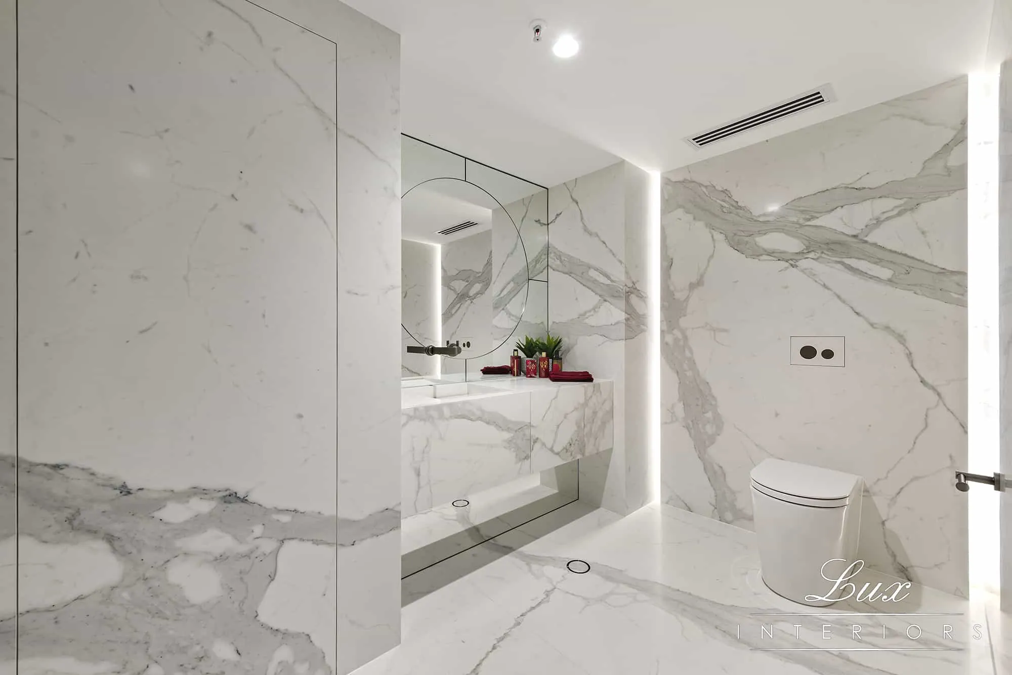 A photo of a bathroom with a huge mirror, sink and toilet.