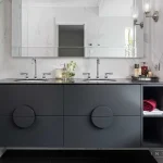 A photo of a bathroom with a black sink, large mirror, with bath and showers on each side.