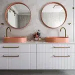 A photo of a bathroom with two mirrored sinks, with 2 round mirrors above them.