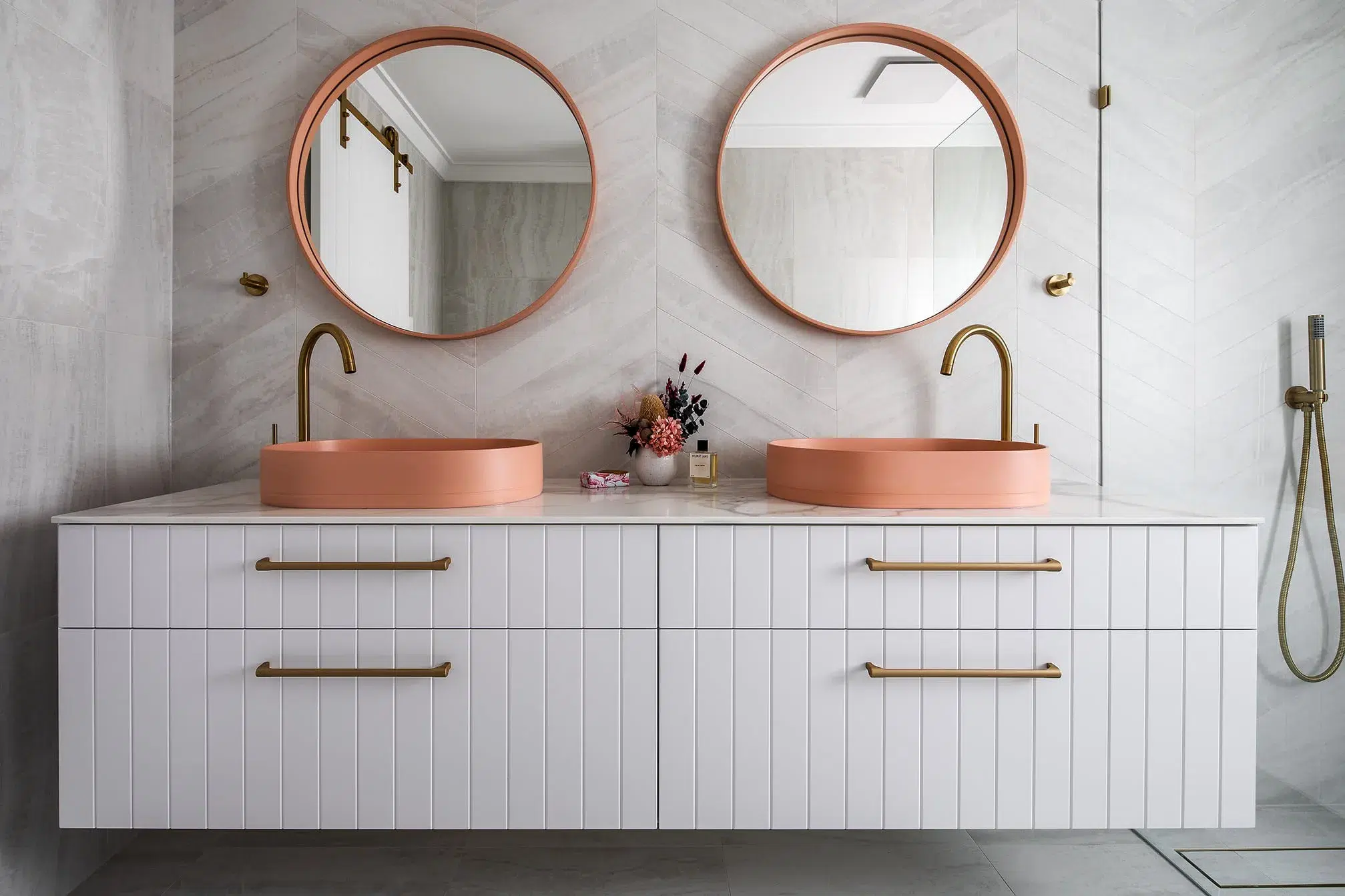 A photo of a bathroom with two mirrored sinks, with 2 round mirrors above them.