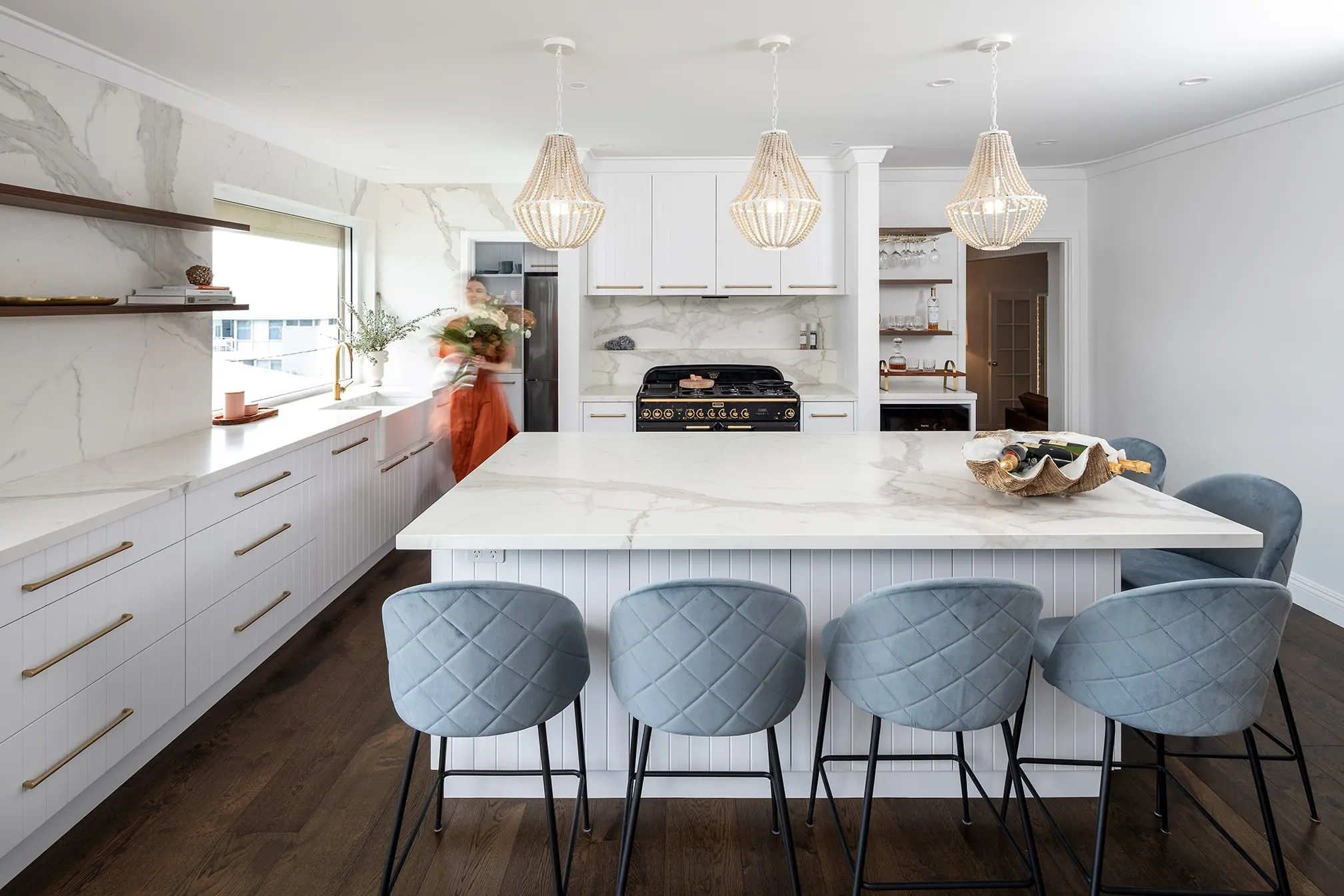 A photo of a kitchen with a table, chairs, stove and various other items you would expect in a kitchen.