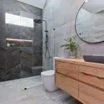 A photo of a bathroom with a shower, toilet and sink.