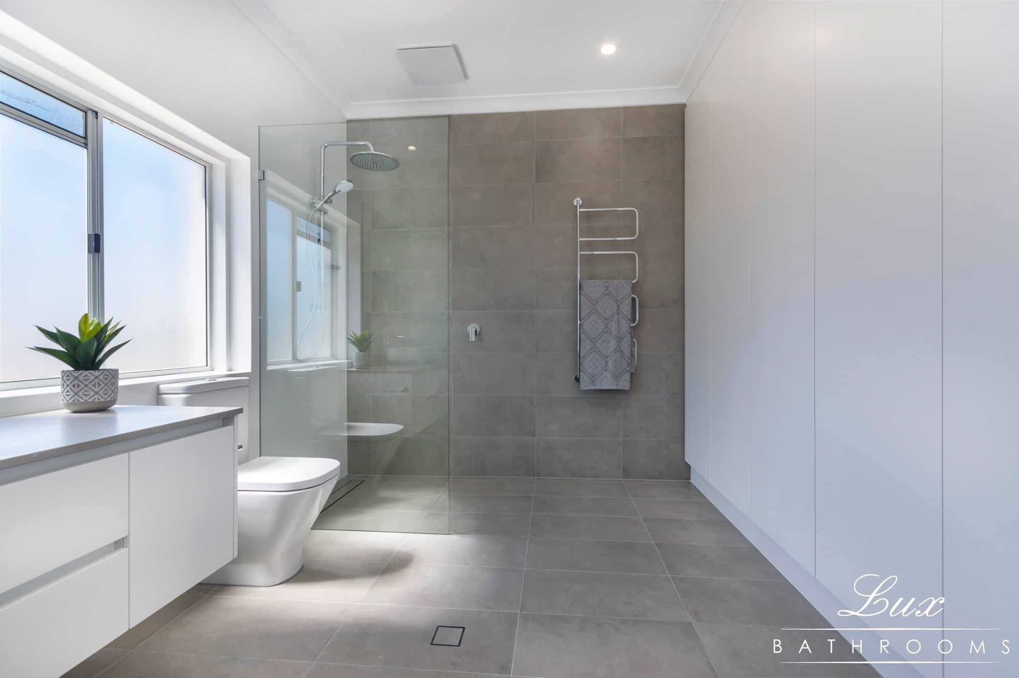 A photo of a bathroom, with a sink, toilet and shower.